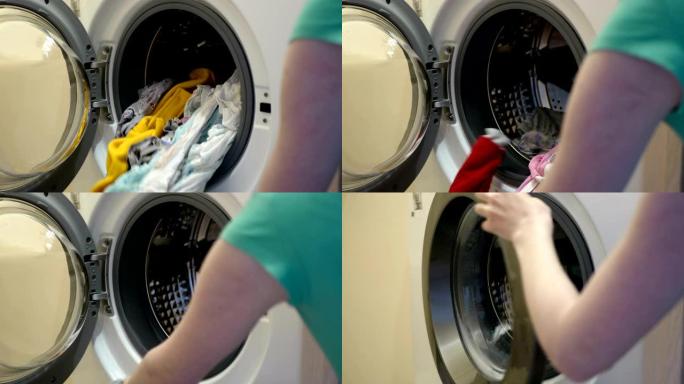 女人拿出洗衣机洗干净的衣服。