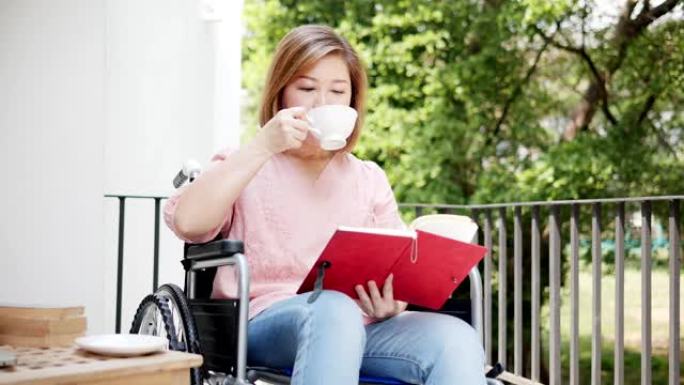 亚洲祖母坐在轮椅上看书，喝咖啡。