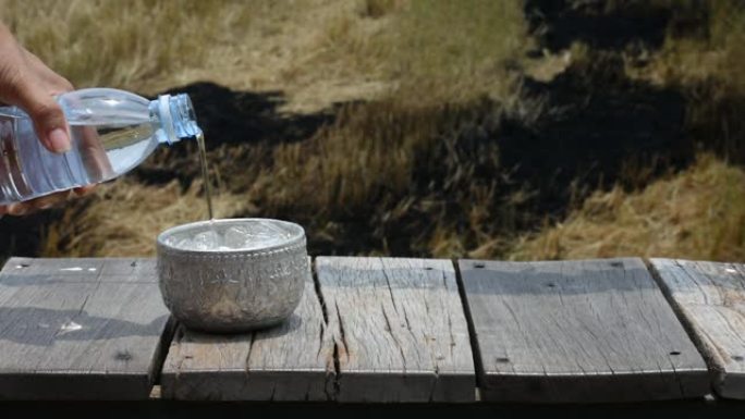 木桌上装有冰的不锈钢碗装满水。