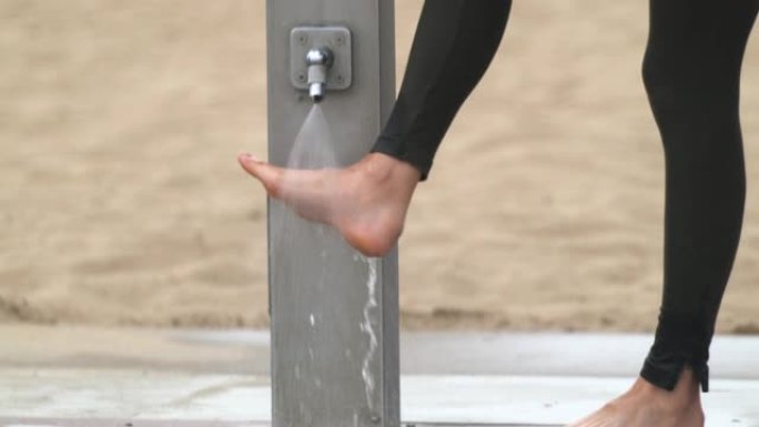 关闭白人妇女在海滩淋浴时洗脚