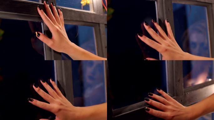 一个女人的手的特写镜头将他的手放在旧窗户上。万圣节。