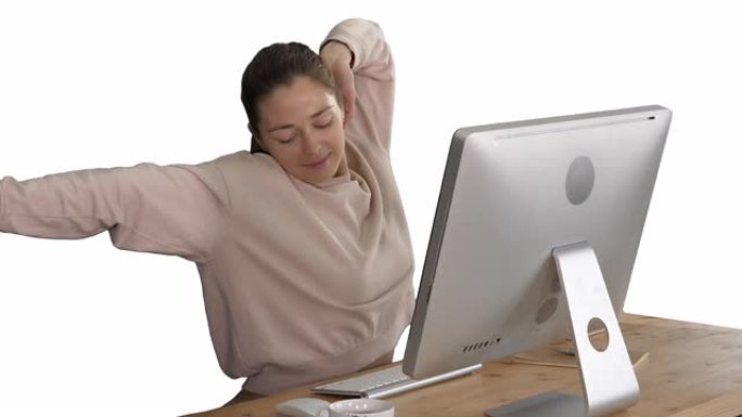 快乐轻松的年轻女子坐在白色背景的电脑前伸展