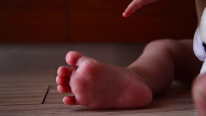 婴儿脚和母亲手指的特写
