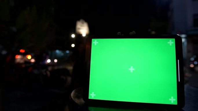(色度键/绿屏) 数字平板电脑上的绿屏，带有夜间街道延时背景