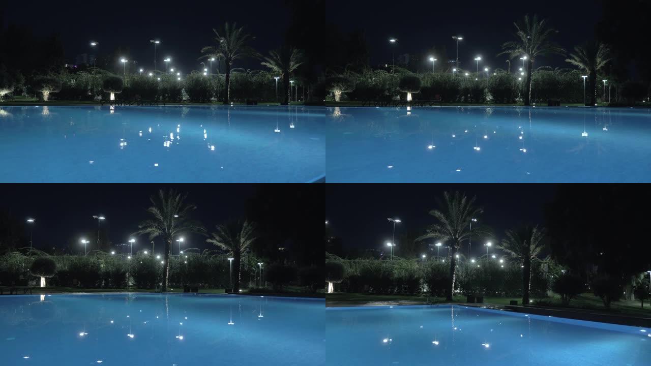 夜间照明中光滑的开放式泳池表面的steadicam镜头