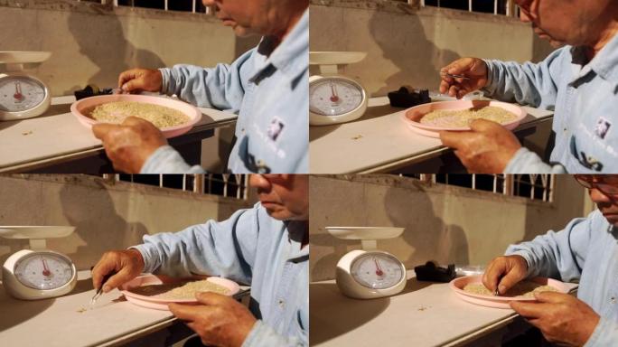 CU Dolly left Camera of Senior man用镊子清除糙米中的异物。