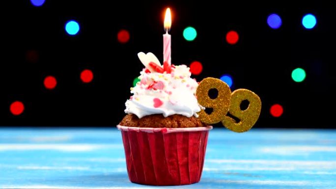 美味的生日蛋糕，蜡烛燃烧，彩色模糊灯光背景上有99号