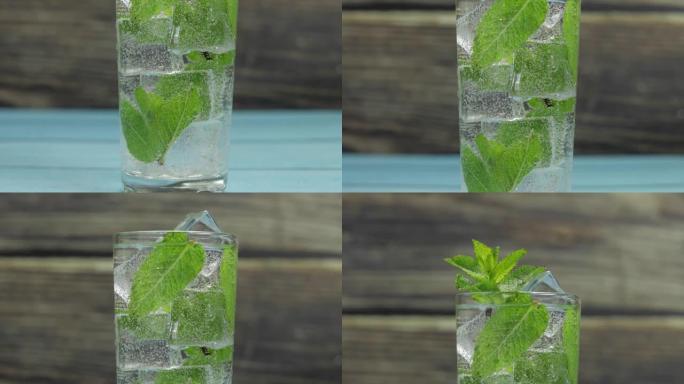 装有绿色薄荷叶和冰块的玻璃杯中的清水