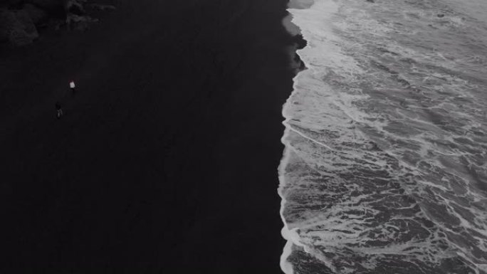 海浪冲向冰岛黑沙滩的航拍画面。
