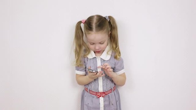 小女孩学习使用智能手机，白色背景上的儿童肖像