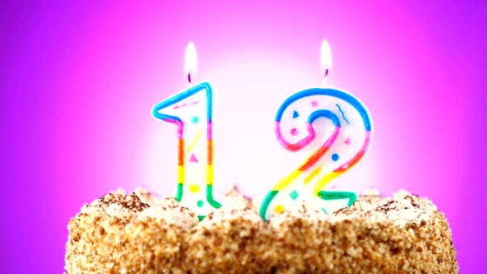 带有燃烧的生日蜡烛的生日蛋糕。12号。背景改变颜色