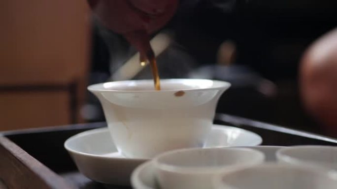 中国传统功夫或功夫茶道。茶师将发酵的绿茶倒入盖湾或中。中国传统文化的元素。特写。4k