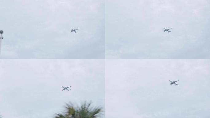迈阿密机场天空中的飞机在夏天从一辆天空多云的汽车上起飞，棕榈树前景广阔。