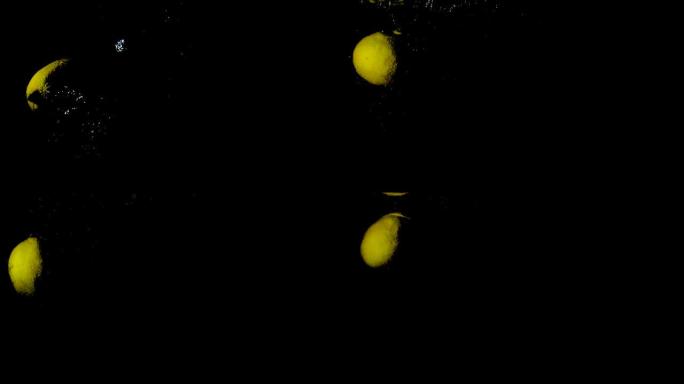 柠檬落入水中会在黑色背景上产生大量气泡。