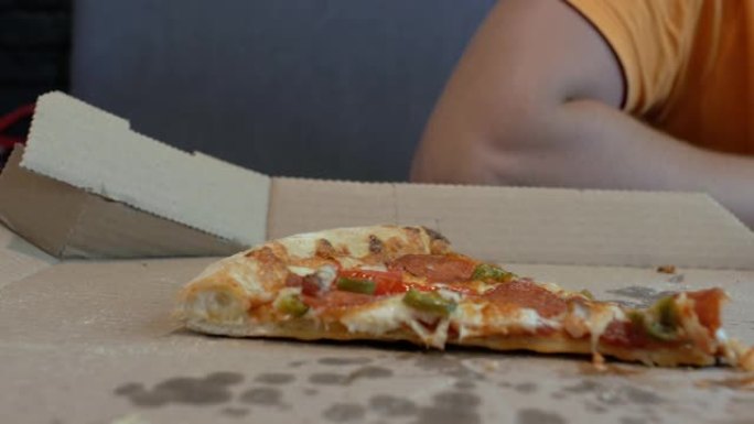 特写最后一片披萨放在一个人背景下的披萨盒里。4k。4k视频