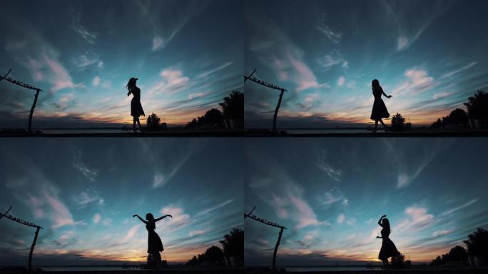 芭蕾舞演员在日落天空中跳舞的剪影。女孩踮起脚尖跳舞旋转。
