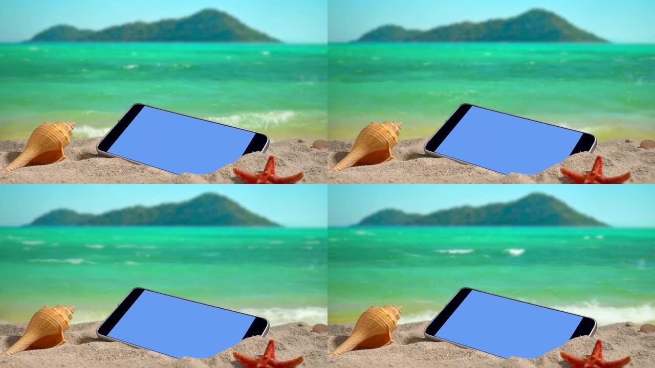 日落时在海滩上打开屏幕的手机。