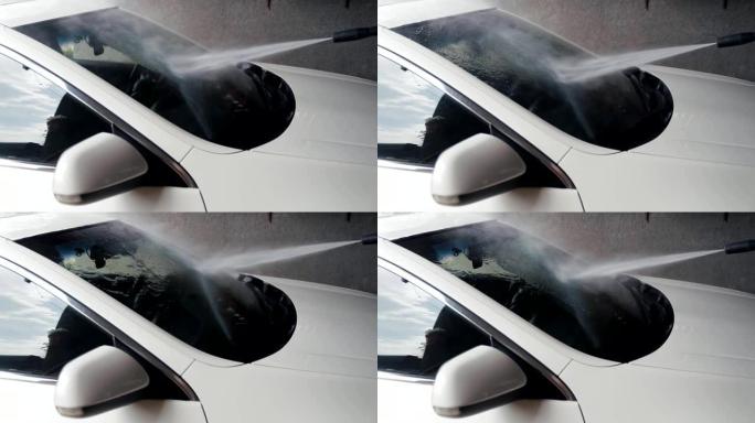 洗车。高压喷射水清洁汽车挡风玻璃。慢动作