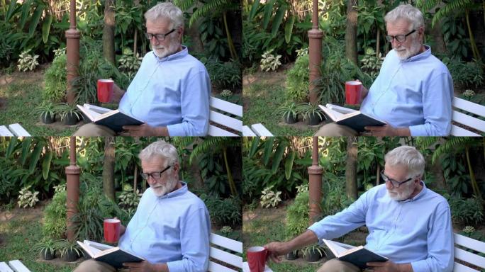 年长的老人拿着咖啡杯在花园里读书，然后把它放在桌子上，翻开书页