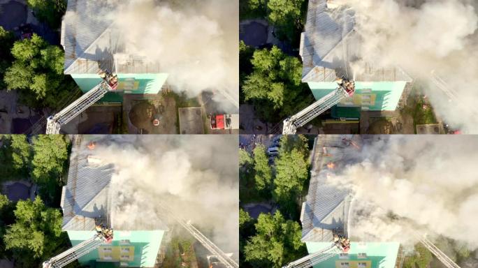 楼梯上的消防员扑灭了一栋住宅高层建筑屋顶的大火。顶视图