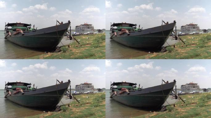 旧的挖泥驳船绑在河岸上，管段保持在水面之外。停泊为背景的河流巡游