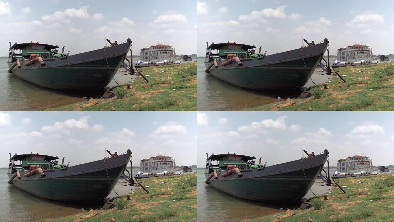 旧的挖泥驳船绑在河岸上，管段保持在水面之外。停泊为背景的河流巡游