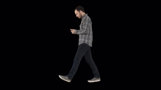 年轻聪明的休闲男人在手机上行走和阅读消息，阿尔法频道