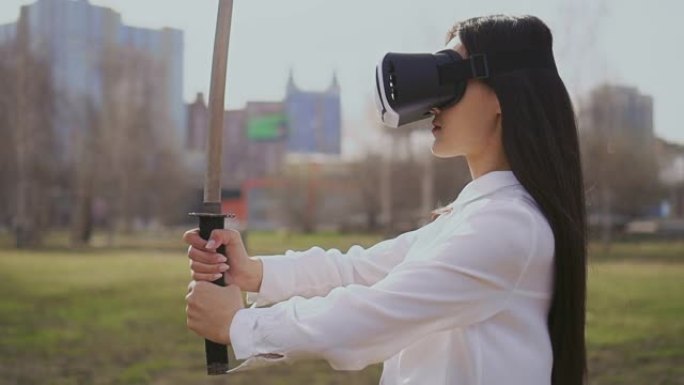 中国女孩用虚拟现实眼镜看剑。风吹在头发上。
