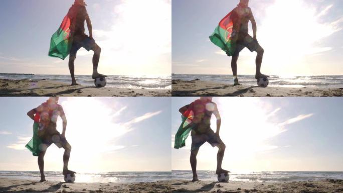 戴着葡萄牙葡萄牙国旗的年轻人，脚踩着足球站在海边的沙滩上，日落时看着海滩上的海洋摄像机steadyc