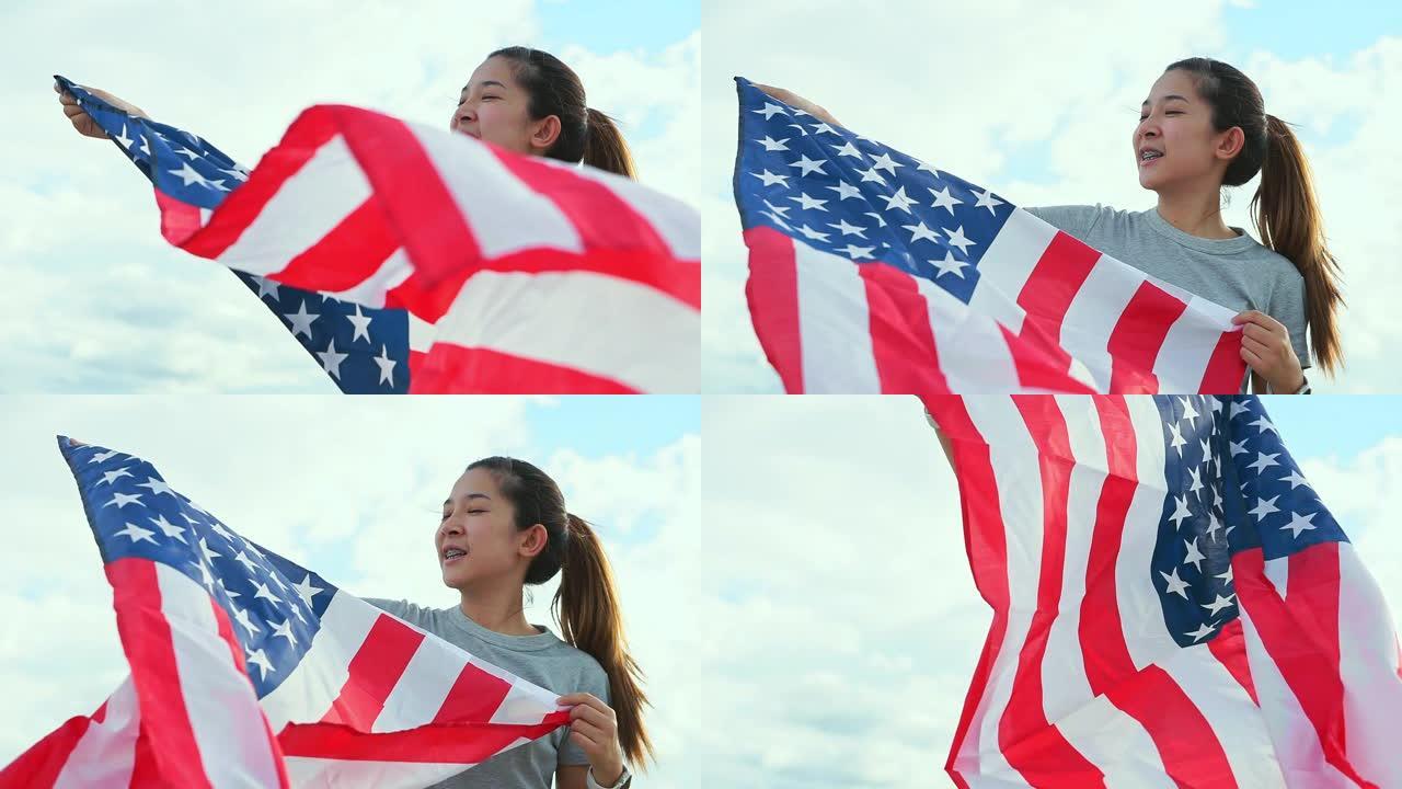 快乐的亚洲妇女与美国国旗美国庆祝7月4日