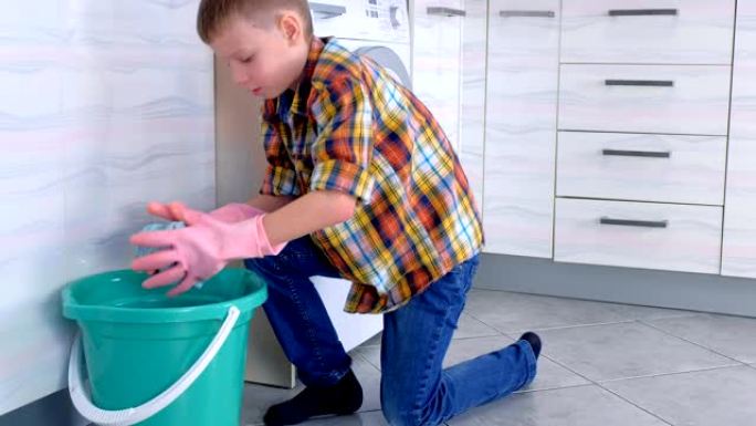 戴着橡胶手套的男孩将布压在水桶上，洗厨房地板。