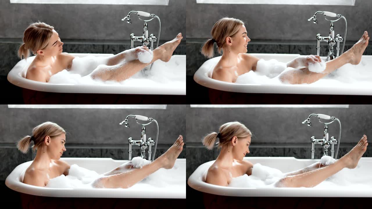 微笑性感的年轻女子洗美丽的腿，用一缕放松洗澡全镜头