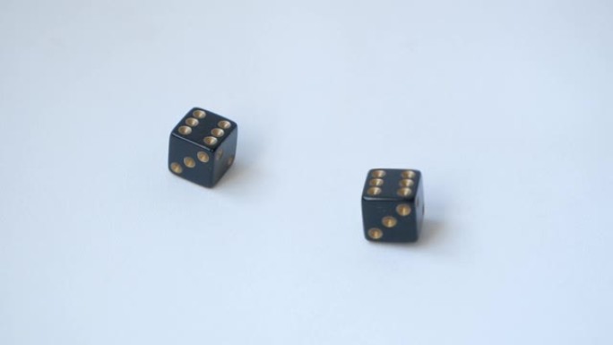 两个黑色骰子以慢动作在桌子上滚动一对六号