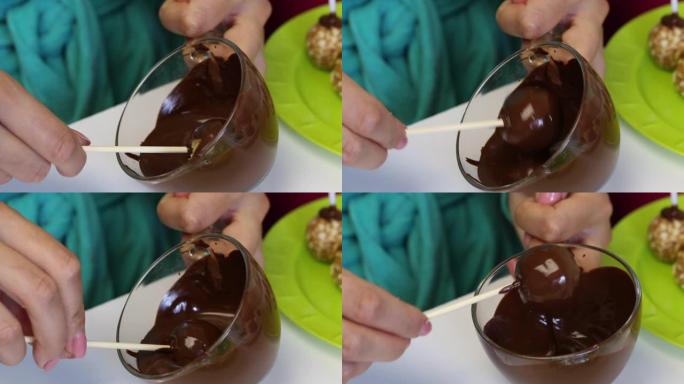 一个女人在融化的黑巧克力中蘸一个爆米花方坯。