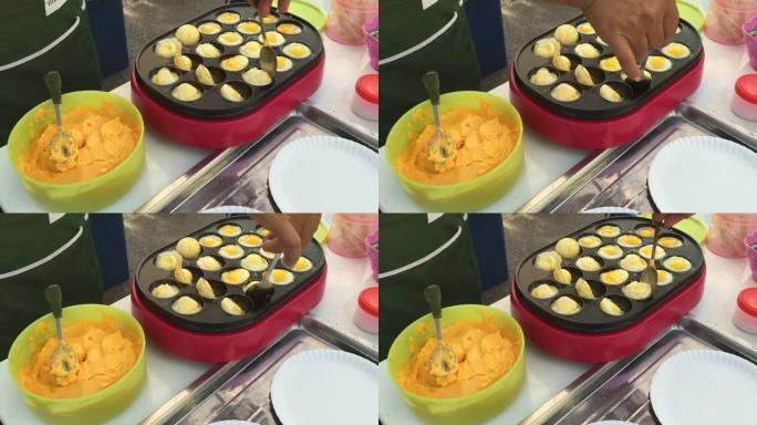 泰国街头小贩在沸腾的锅里炸薯条小鹌鹑蛋