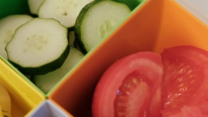 带牢房的午餐盒。蔬菜，黄瓜和西红柿，煮土豆和肉饼。