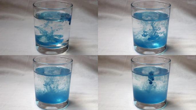 一杯水中的一滴蓝色油漆