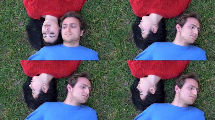 年轻夫妇躺在草地上转头。不可沟通