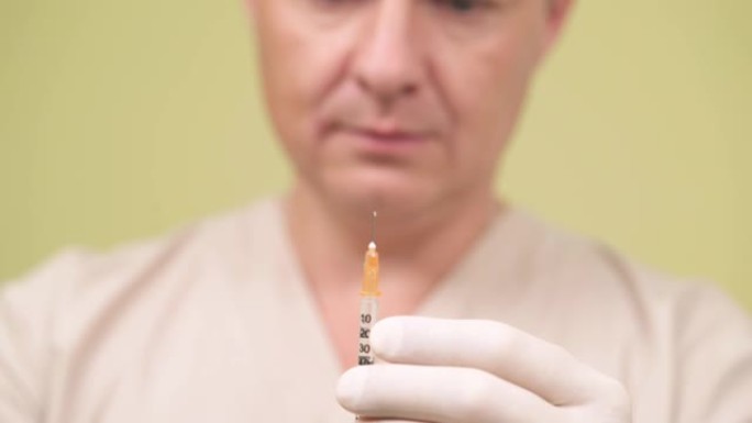 医学，糖尿病，保健概念。医生拿着胰岛素注射注射器的特写镜头。孤立，在模糊的背景上