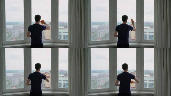 一名男子洗了一扇俯瞰城市的窗户