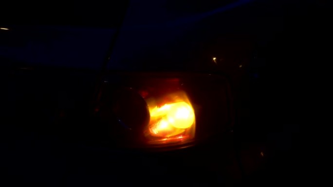 夜间停在侧面的汽车上闪烁橙色闪光灯