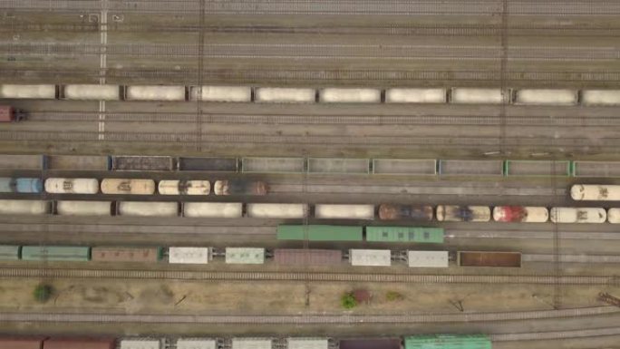 火车站的货运列车。鸟瞰图。在一个阳光明媚的夏日，载着货物的油罐和集装箱在铁路上。商业轨道交通