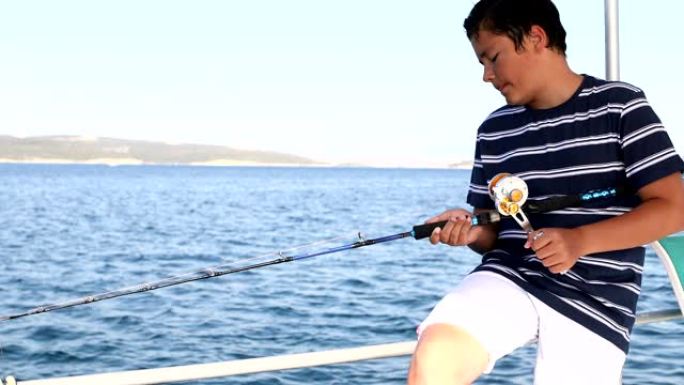 少年男孩在暑假在船上钓鱼