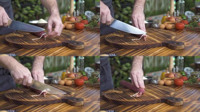 厨师在木板上切香肠特写。烹饪披萨的男性手切香肠。加工准备意大利食品。地中海美食概念