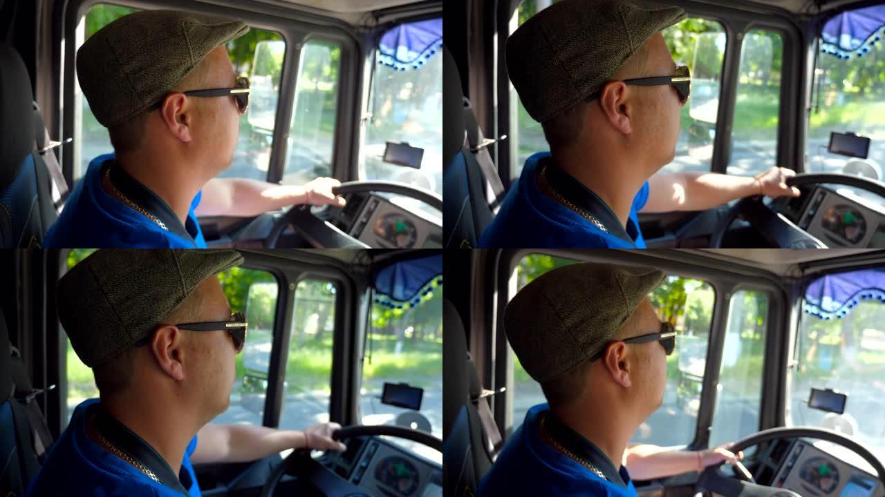 货车司机在机舱内的简介，在城市道路上骑行，在阳光明媚的日子里享受旅程。戴着帽子和墨镜的男子控制着他的