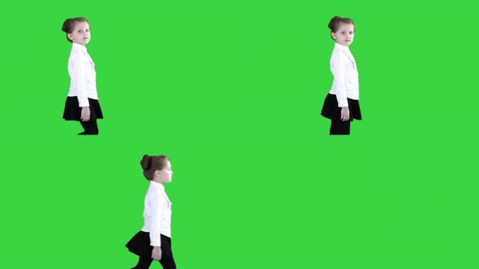 走路的小女孩停下来，看着绿色屏幕上的相机，色度键