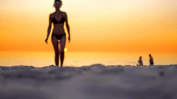 日落时，年轻的拉丁美洲女孩在海洋海滩上行走的光脚
