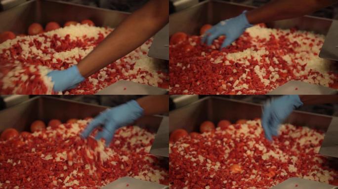 商用厨房食品制备-洋葱和冷冻红辣椒放在30加仑的煎锅中