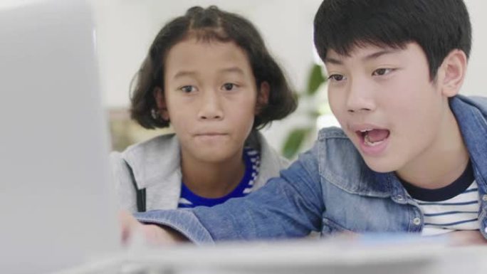 年轻的男孩正在使用计算机来教和解释作业。对有面部表情和快乐手势的朋友，多莉拍摄60fps。