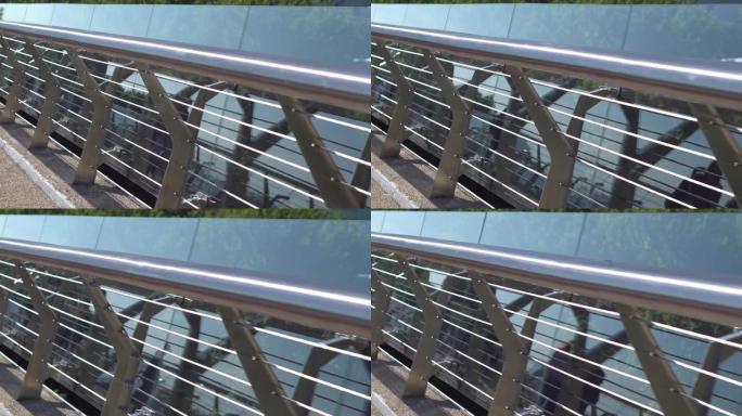 市内人行天桥的一部分。金属和玻璃栏杆，以确保人们的安全。特写
